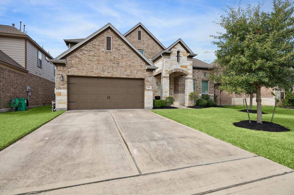 Charming brick home with a neatly maintained front yard. The entrance features an inviting archway and covered area for guest.