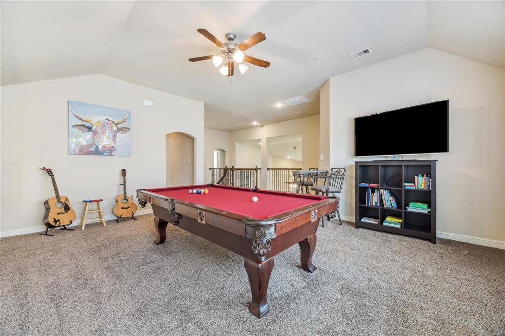 This spacious game room features a pool table with plenty of room for the TV area and sitting/ refreshment area.