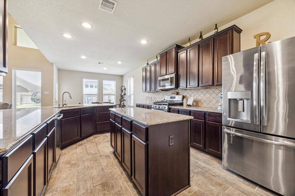 Features of this kitchen include stainless steel appliances, sweeping granite countertops, ample natural light from large windows, a central island which offers additional workspace and seating,is perfect for cooking and entertaining.