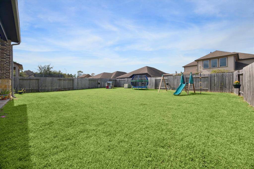 Spacious backyard with lush green lawn, perfect for families. Imagine all the room for play, putting green, volleyball court or pool. Ideal for outdoor activities and gatherings.