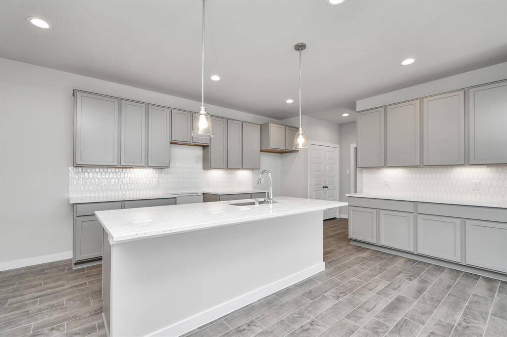 Discover another perspective of this stunning kitchen, generously appointed with an abundance of counter space. Sample photo of completed home with similar floor plan. As-built interior colors and selections may vary.