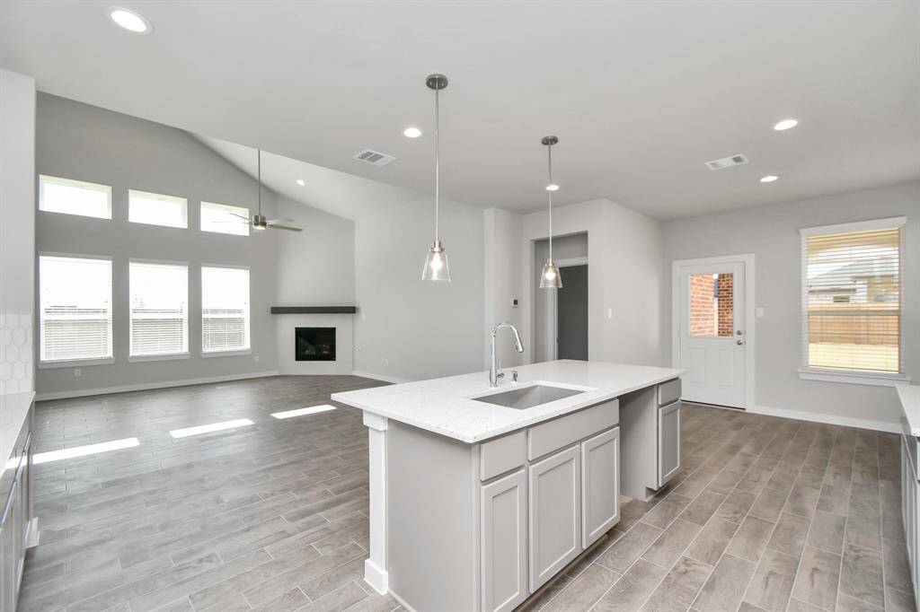 Discover another perspective of this stunning kitchen, generously appointed with an abundance of counter space. Sample photo of completed home with similar floor plan. As-built interior colors and selections may vary.