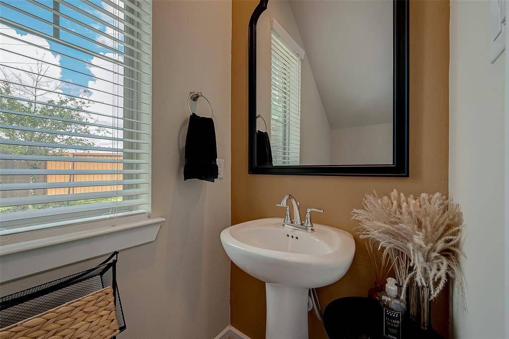 Located on the first floor, this stylish half bath features modern fixtures and a sleek design. Its convenient location and elegant finishes make it a perfect addition for guests and everyday use.