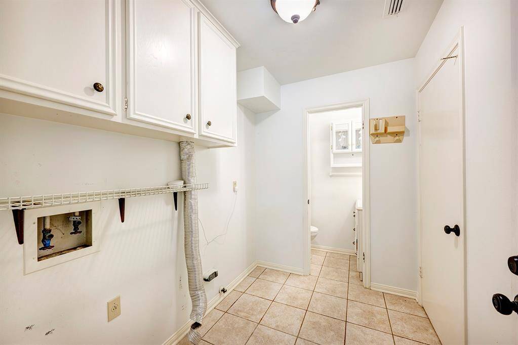 Laundry room off the breakfast room also houses a half bathroom. Door from the backyard makes this a multi-purpose laundry/mudroom.