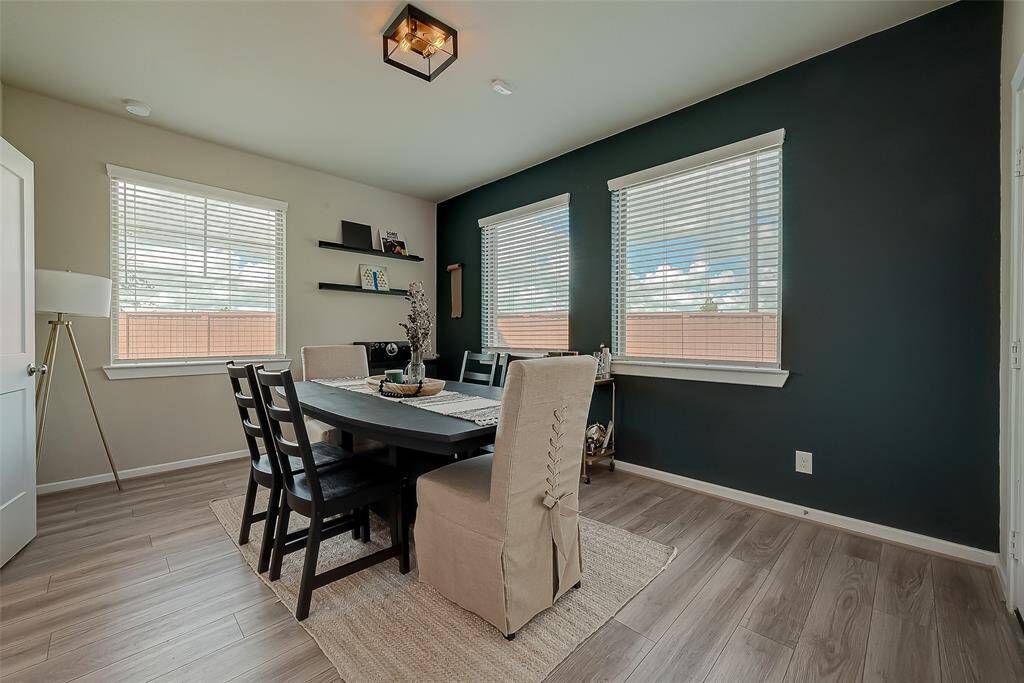 Step into this inviting family room/loft on the first floor of a stunning three-story home. Bathed in natural light from large windows with backyard views, the open-concept design seamlessly connects indoor and outdoor spaces. Elegant flooring, no carpet, and a versatile layout make it perfect for gatherings.