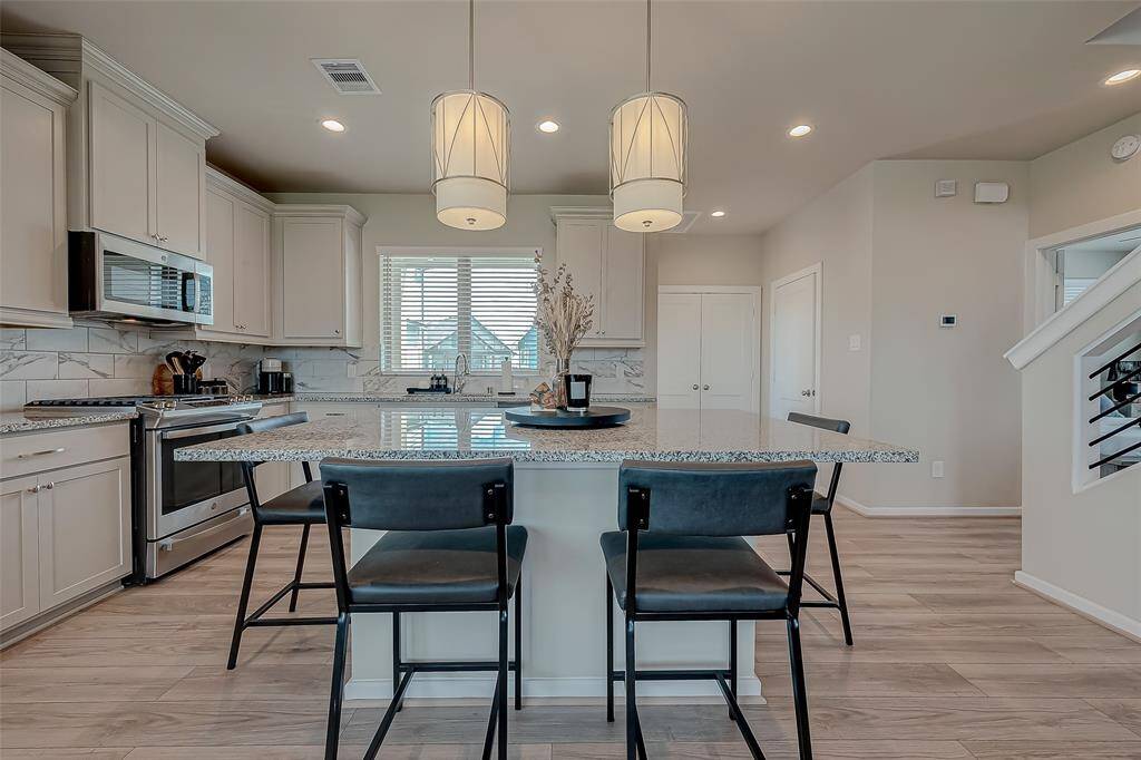 Discover the updated kitchen, featuring modern appliances, ample lighting, and an oversized island. This stylish and functional space is perfect for cooking and entertaining, offering a contemporary design that enhances the heart of the home.