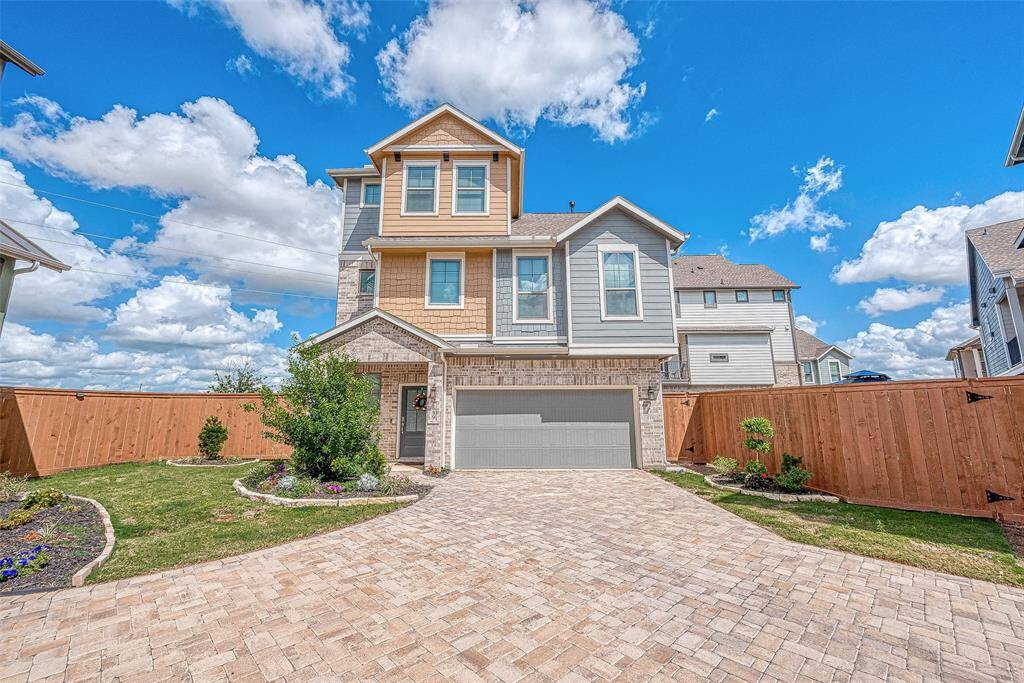 Experience the spacious living room on the second floor of this three-story home. Featuring ample lighting, sleek flooring with no carpet, and a stylish TV wall unit with an electronic fireplace, this inviting space is perfect for relaxation and entertainment.