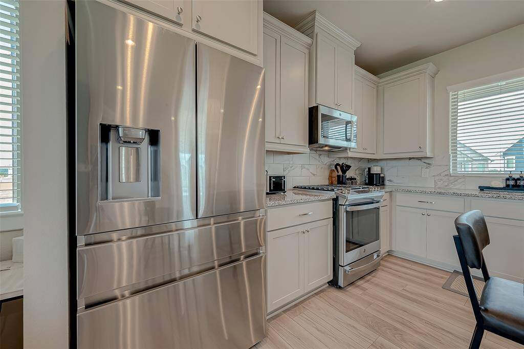 Discover the updated kitchen, featuring modern appliances, ample lighting, and an oversized island. This stylish and functional space is perfect for cooking and entertaining, offering a contemporary design that enhances the heart of the home.