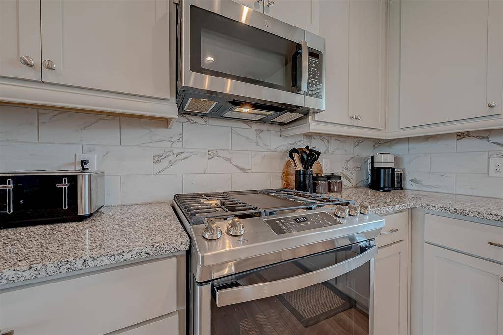 Discover the updated kitchen, featuring modern appliances, ample lighting, and an oversized island. This stylish and functional space is perfect for cooking and entertaining, offering a contemporary design that enhances the heart of the home.