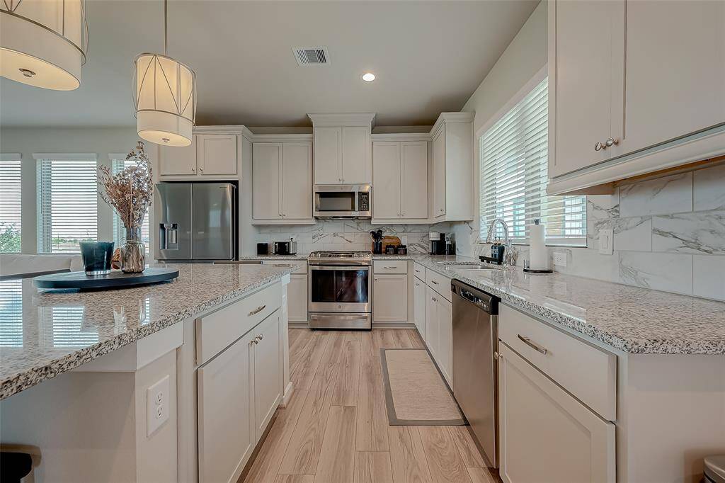 Discover the updated kitchen, featuring modern appliances, ample lighting, and an oversized island. This stylish and functional space is perfect for cooking and entertaining, offering a contemporary design that enhances the heart of the home.