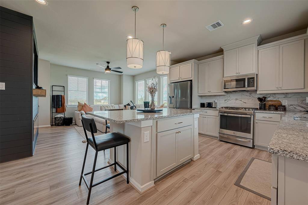 Discover the updated kitchen, featuring modern appliances, ample lighting, and an oversized island. This stylish and functional space is perfect for cooking and entertaining, offering a contemporary design that enhances the heart of the home.