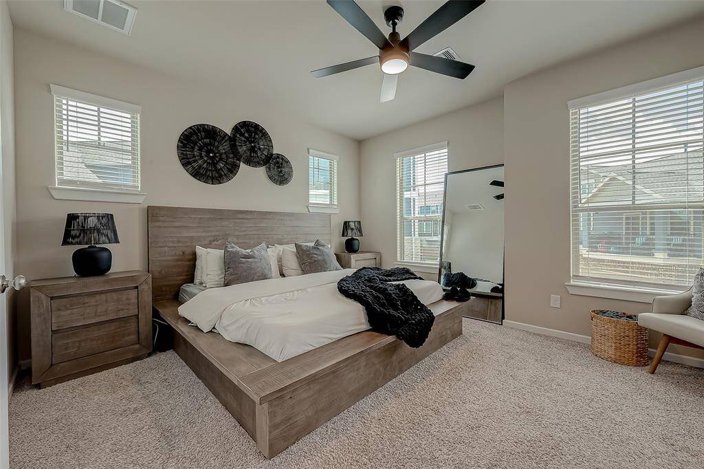 The spacious primary bedroom suite is flooded with natural light, creating a bright and airy atmosphere. With ample room, it offers a comfortable and inviting retreat, perfect for relaxation and personal enjoyment.