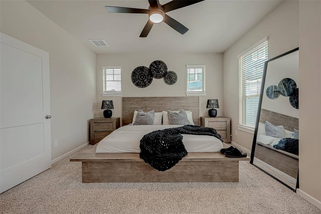 The spacious primary bedroom suite is flooded with natural light, creating a bright and airy atmosphere. With ample room, it offers a comfortable and inviting retreat, perfect for relaxation and personal enjoyment.