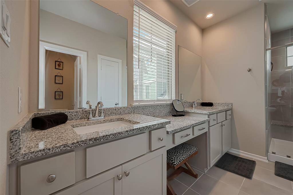 The full-size primary ensuite features a spacious shower, double sinks, and ample closet space. This luxurious bathroom offers modern amenities and elegant design, providing a perfect retreat for relaxation and convenience.