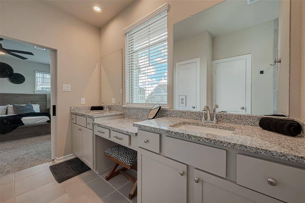 The full-size primary ensuite features a spacious shower, double sinks, and ample closet space. This luxurious bathroom offers modern amenities and elegant design, providing a perfect retreat for relaxation and convenience.