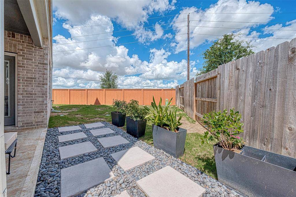 Enjoy a nice-sized backyard featuring a custom covered patio area, perfect for outdoor dining and relaxation. This inviting space offers ample room for activities and gatherings, making it an ideal spot for entertaining and enjoying the outdoors.