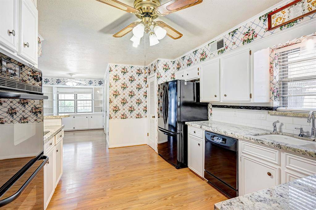 Granite kitchen with double ovens, refrigerator and pantry.