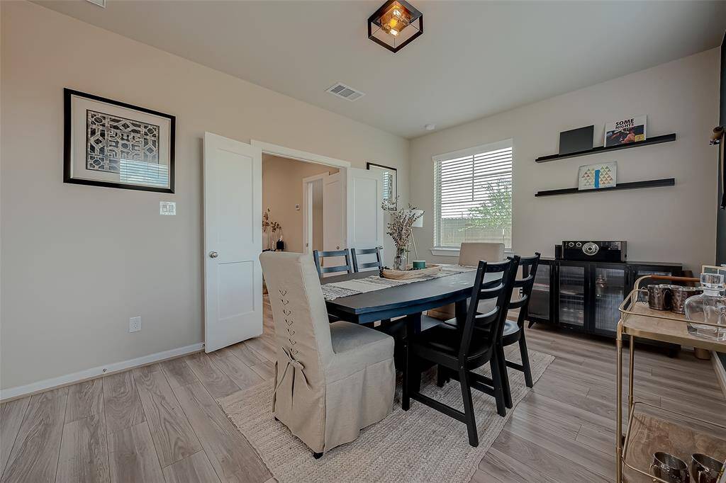 Step into this inviting family room/loft on the first floor of a stunning three-story home. Bathed in natural light from large windows with backyard views, the open-concept design seamlessly connects indoor and outdoor spaces. Elegant flooring, no carpet, and a versatile layout make it perfect for gatherings.