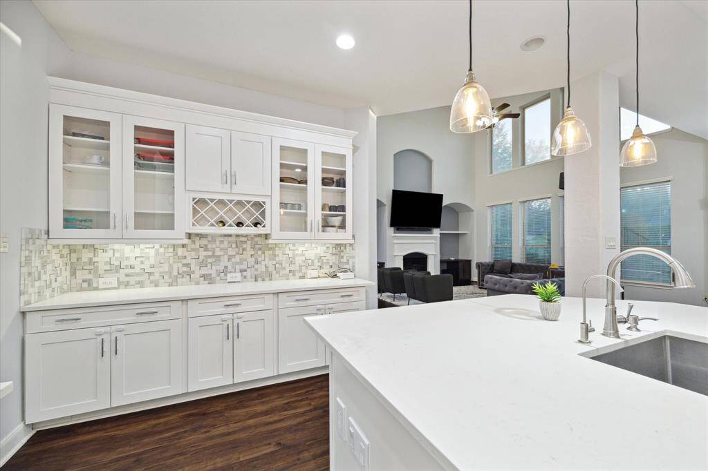 Enjoy sleek quartz countertops and abundant cabinet space for all your kitchen essentials. The breakfast bar offers a perfect spot for morning meals, while the modern tile backsplash adds a touch of style to the space.