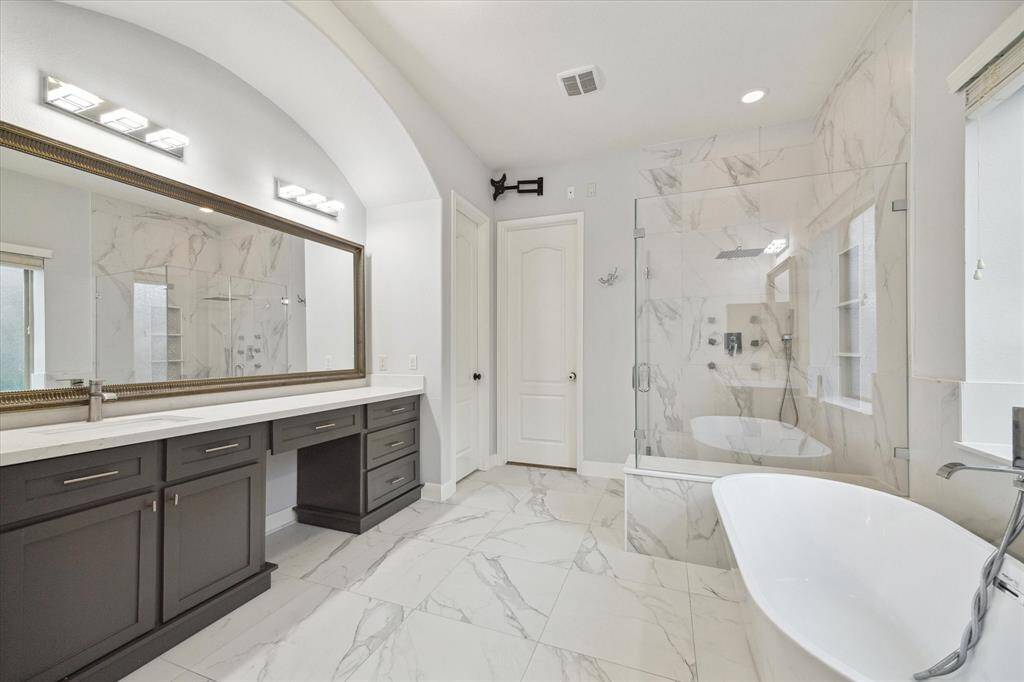 Step into the luxurious primary en-suite to unwind & relax. The large vanity area is complemented by a wall-to-wall mirror, enhancing the sense of space while providing ample room for all your personal essentials.