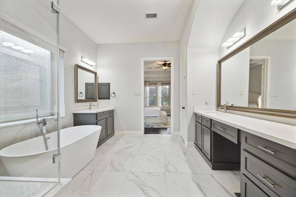 This luxe bathroom offers an ample soaking tub and an oversized frameless shower, with high-end finishes that create a serene, spa-like atmosphere.