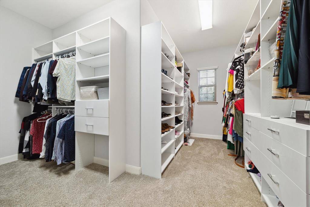 Discover the impressive primary closet, complete with custom built-ins designed for optimal organization. With plenty of space for storing all your clothes, shoes, and accessories, this closet provides both functionality and style to keep everything beautifully arranged.