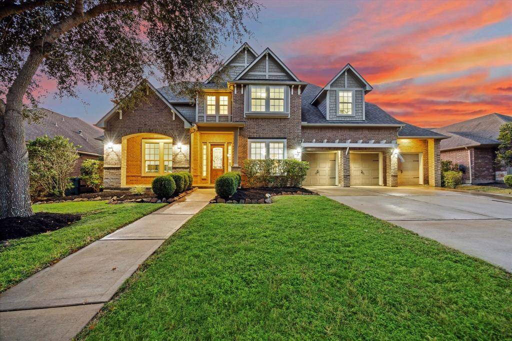 As you approach, you are greeted by lush landscaping that beautifully complements the home's exterior. A paved walkway leads to the covered front entrance, creating a warm and inviting environment that enhances the home’s curb appeal.