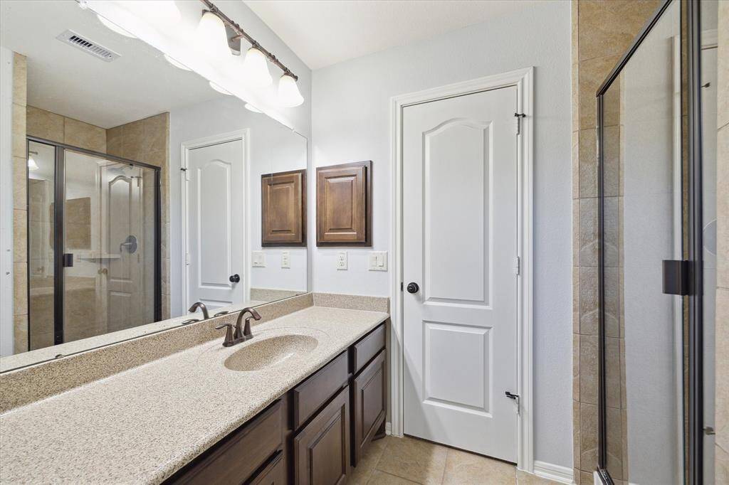 Enjoy the spacious walk-in shower, complemented by a single sink vanity with tons of counter space, large mirror and overhead lights illuminate the space.