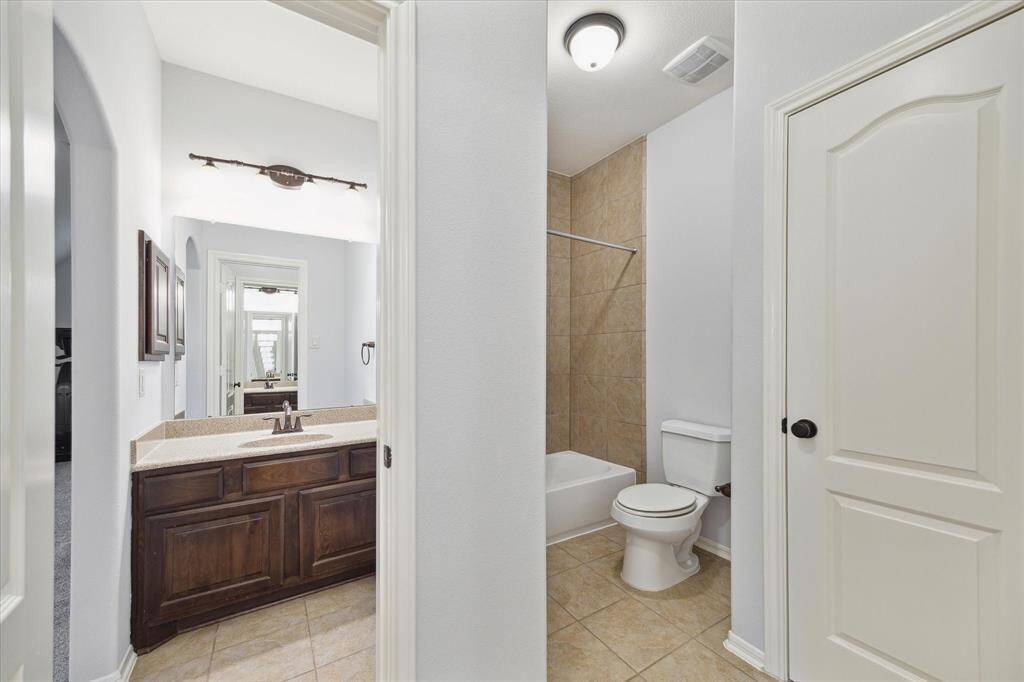 This Jack & Jill bathroom features a tub/shower combo separate from the sink area, providing added convenience and privacy.