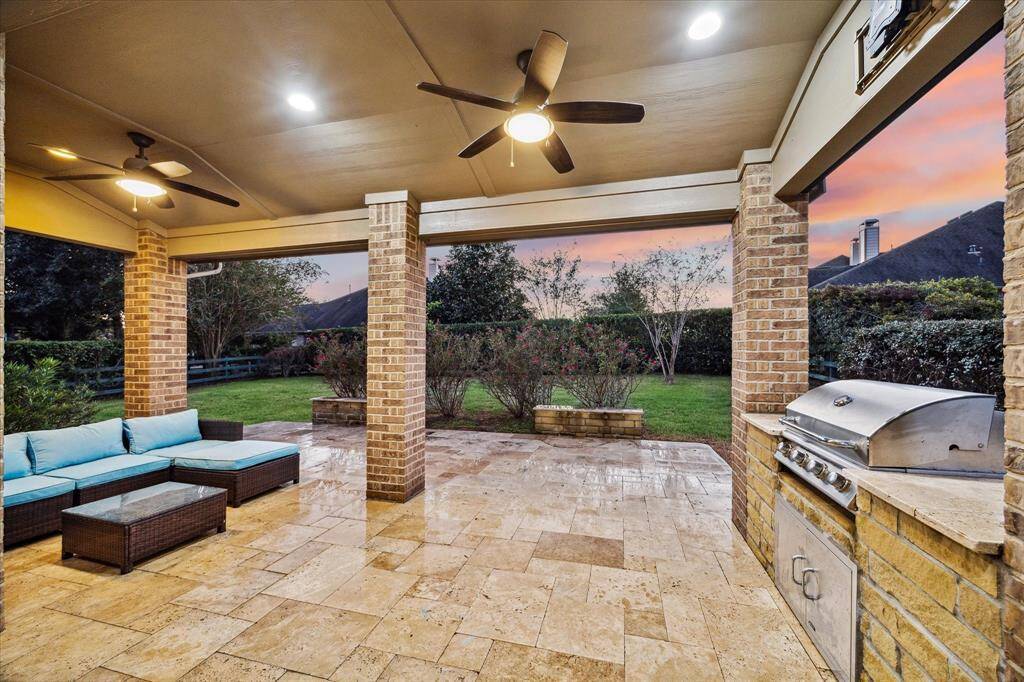 Welcome to your backyard paradise, designed for relaxation and entertaining. Enjoy a built-in grill perfect for outdoor cooking, while travertine tile flooring extends throughout the covered patio. Overhead fans ensure year-round comfort, making this space ideal for any season.