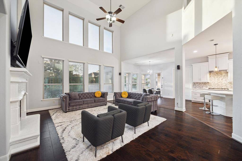 An alternate view of the room showcases the impressive floor-to-ceiling windows, which flood the space with an abundance of natural light, creating a bright and airy atmosphere. The sleek hardwood floors complement the design, adding warmth and sophistication to the room.