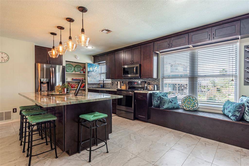 A cozy window seat nestled next to the coffee bar in the kitchen provides the perfect spot to relax with your favorite brew.