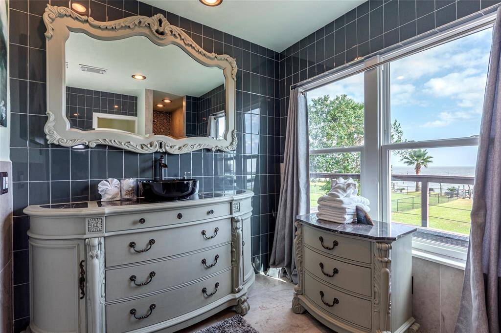 The primary ensuite features a luxurious walk-in shower with a large window that fills the space with natural light, creating an open and airy atmosphere.