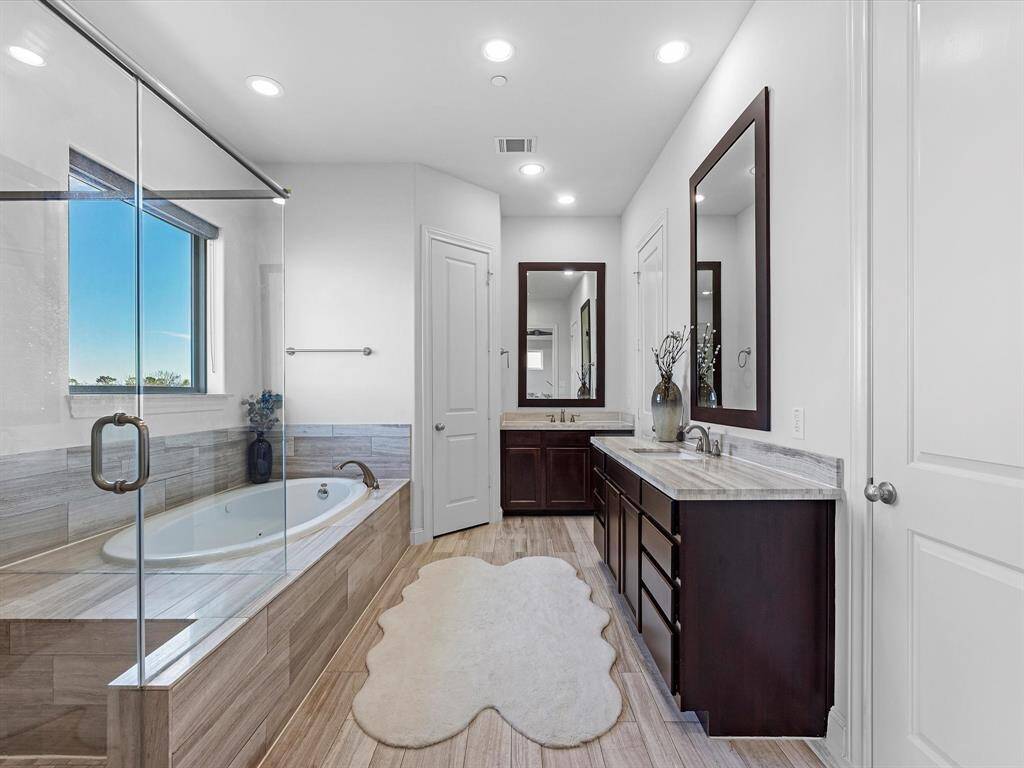The primary en-suite bath features a standing shower, jetted tub, double vanities and his and her closets.
