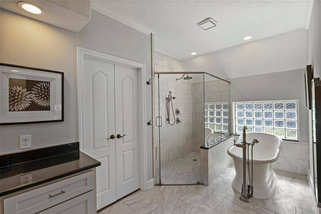 Primary bedroom offers custom walk-in shower with separate soaking tub