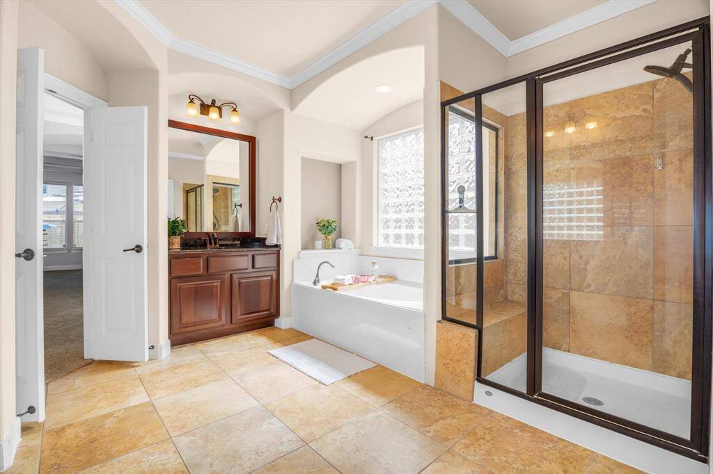 Enjoy the master bath with dual sink and vanities, soaking tub, glass shower with built-in bench AND large master closet