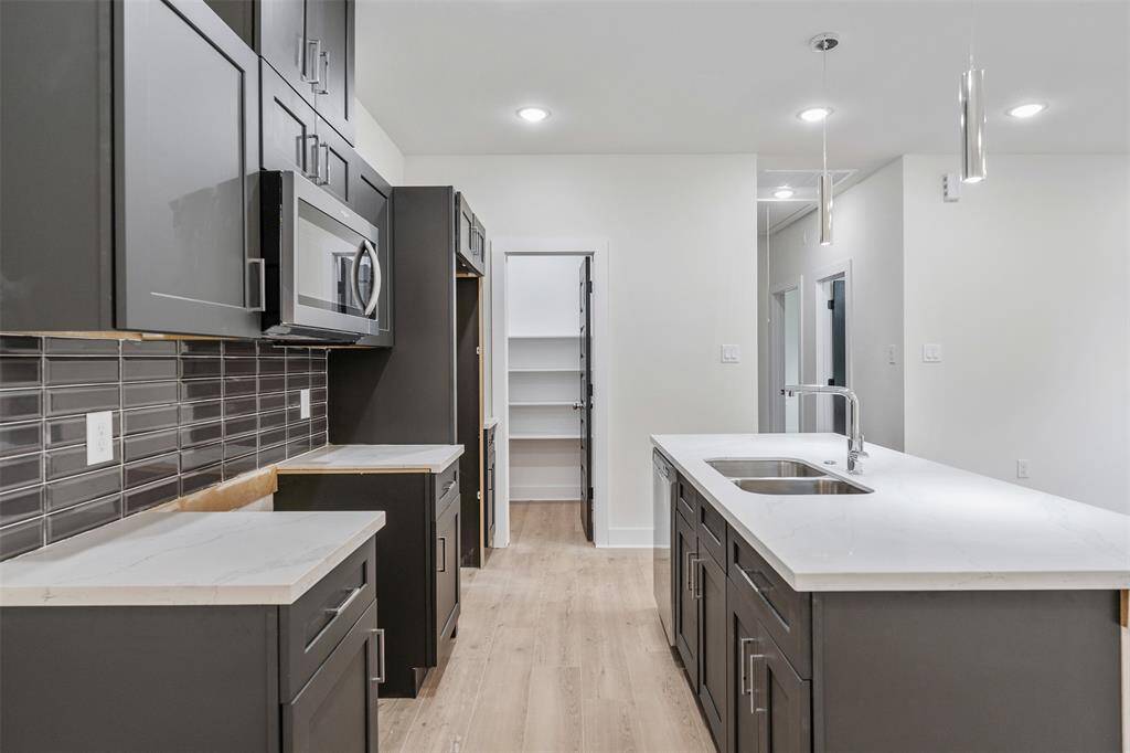 Kitchen features grey cabinets that provides a more softer and inviting appeal. *photos are from builders previous model home with same layout and fixtures*