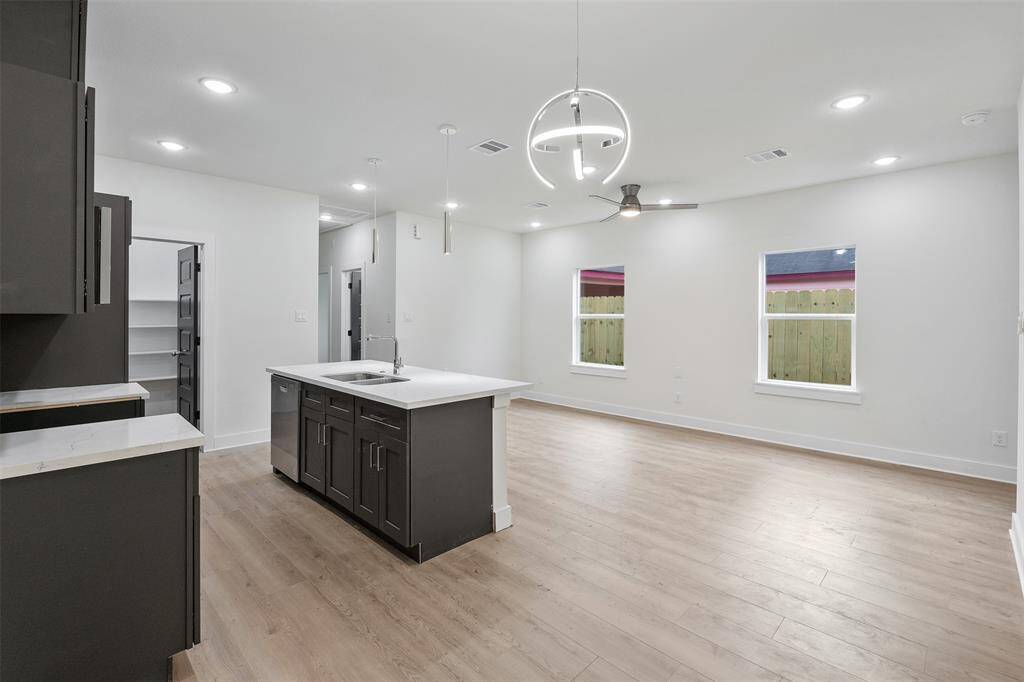 Kitchen view of wooden plank floors and chrome fixtures.*photos are from builders previous model home with same layout and fixtures*