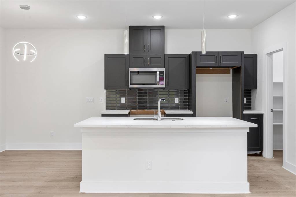 Kitchen island with breakfast bar helps accommodate more guest. *photos are from builders previous model home with same layout and fixtures*