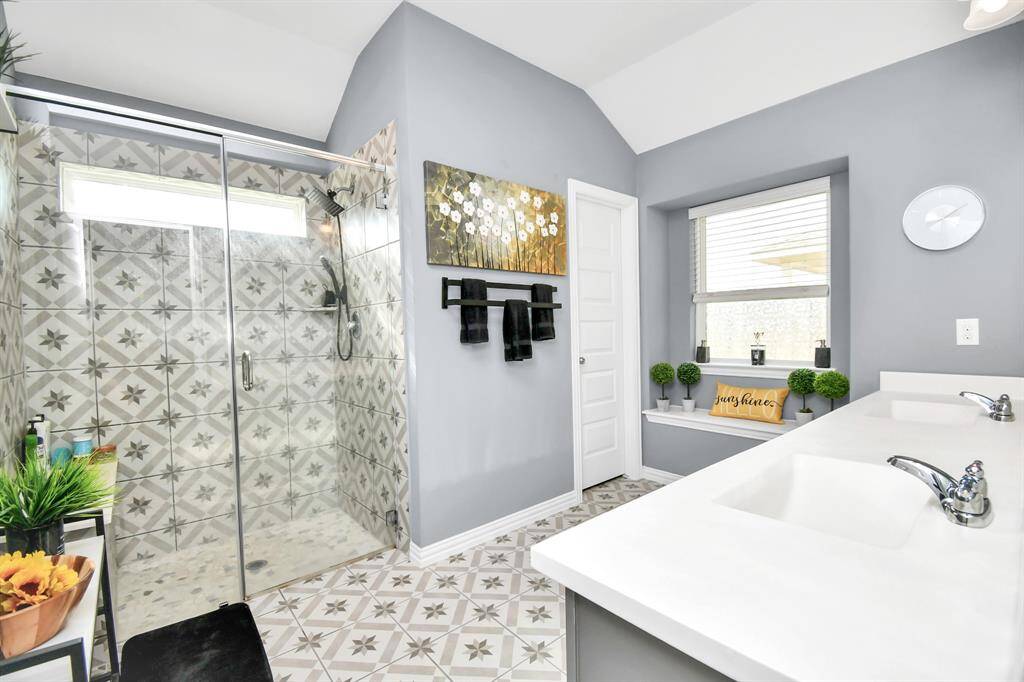 The primary bathroom is a true sanctuary, featuring lovely tile work and a spacious, glass-fronted shower that adds a touch of modern sophistication!