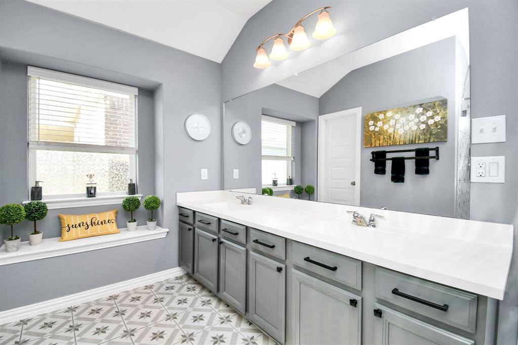 You’ll fall in love with the sleek dual-sink vanity, as well as the charming seating area beneath the window - perfect for a quiet moment or getting ready in comfort!