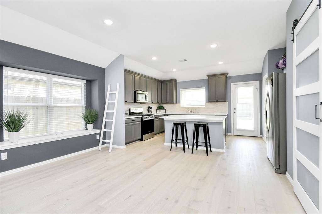 Beyond the living area, you'll find a spacious dining area that flows effortlessly into the kitchen, creating an open-concept layout perfect for gatherings and everyday living!