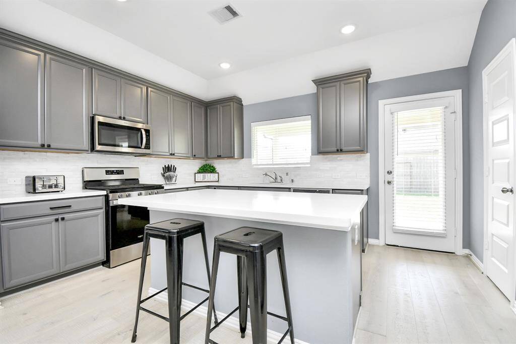 The kitchen is further enhanced by beautiful cabinetry and a spacious island with breakfast bar seating - perfect for casual dining, meal prep and entertaining guests!