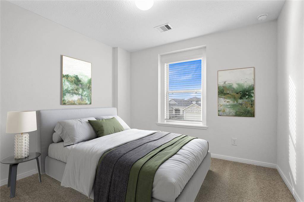 Secondary bedroom features plush carpet, neutral paint, lighting, window with privacy blinds and ample sized closet space.