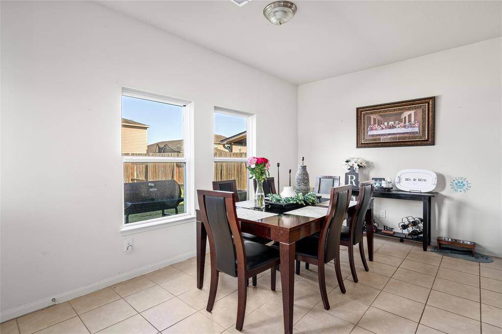 This bright and inviting dining room, adorned with large windows, offers a warm atmosphere for family meals and gatherings. Natural light pours in, enhancing the space and creating a comfortable setting for dining and entertaining.