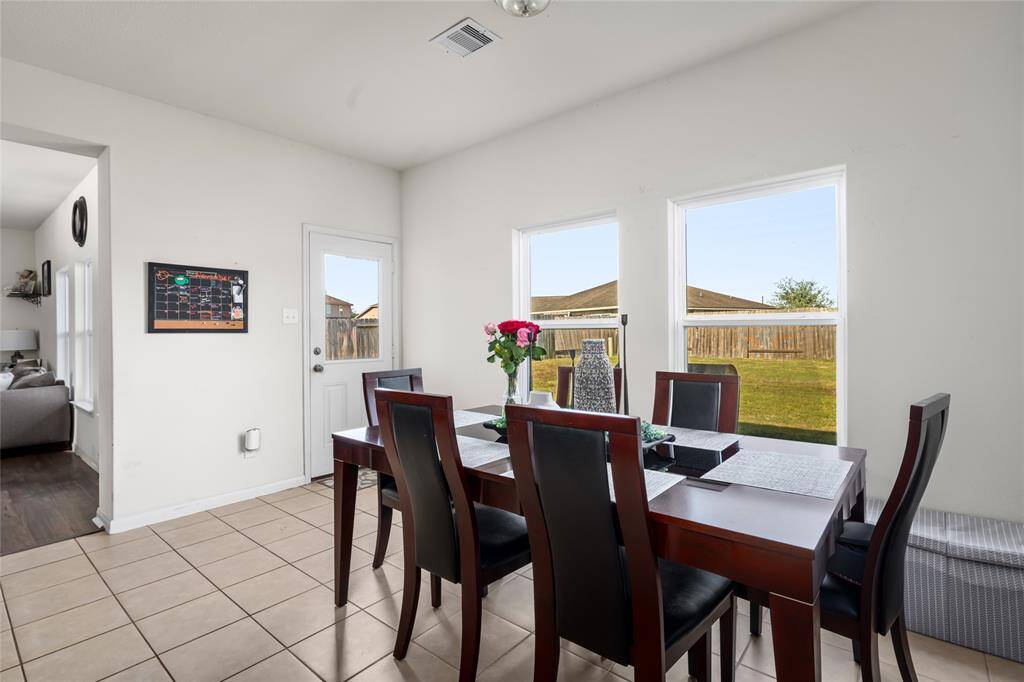 With its beautiful windows, this dining room is bathed in natural light, creating a warm and inviting space for meals and special occasions. The serene view adds to the ambiance, making it a perfect spot for dining and entertaining.