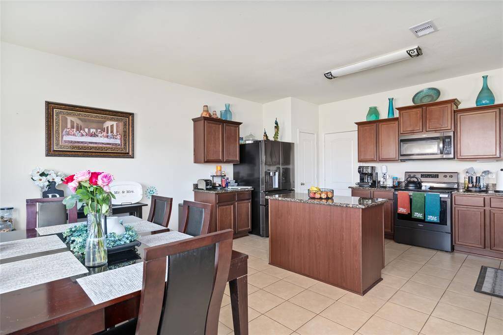 This charming dining room, seamlessly connected to the kitchen, creates an open and flowing space perfect for family meals and entertaining. The convenient layout makes it easy to move between cooking and dining, enhancing both functionality and warmth.