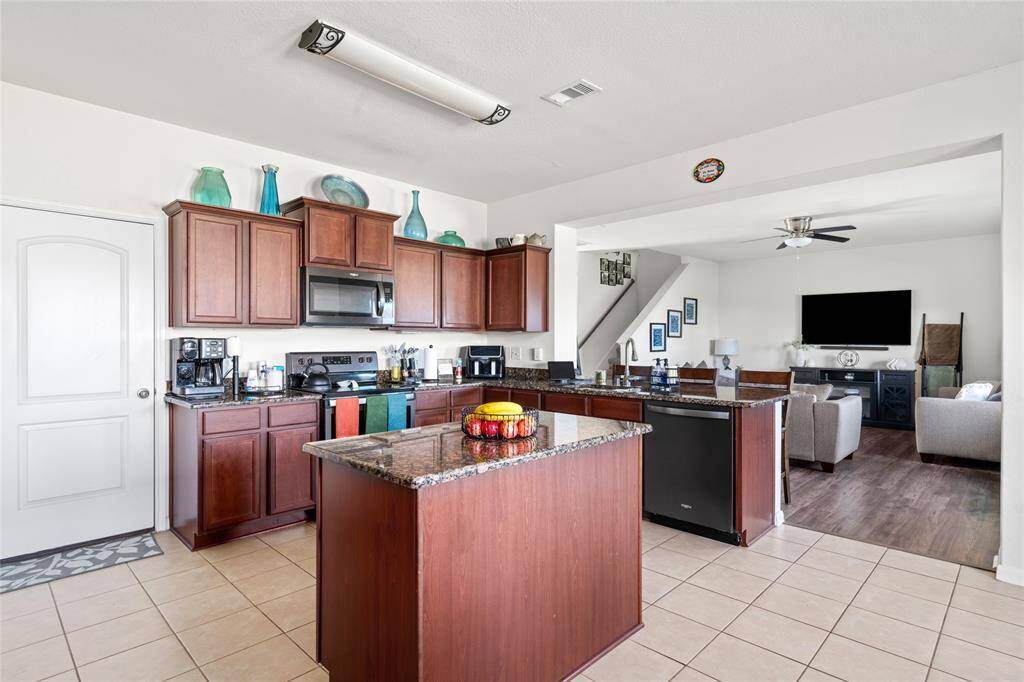 This kitchen features a spacious counter and a convenient breakfast bar, perfect for casual meals or quick snacks. The open layout allows for easy meal prep and serves as a gathering spot for family and friends.