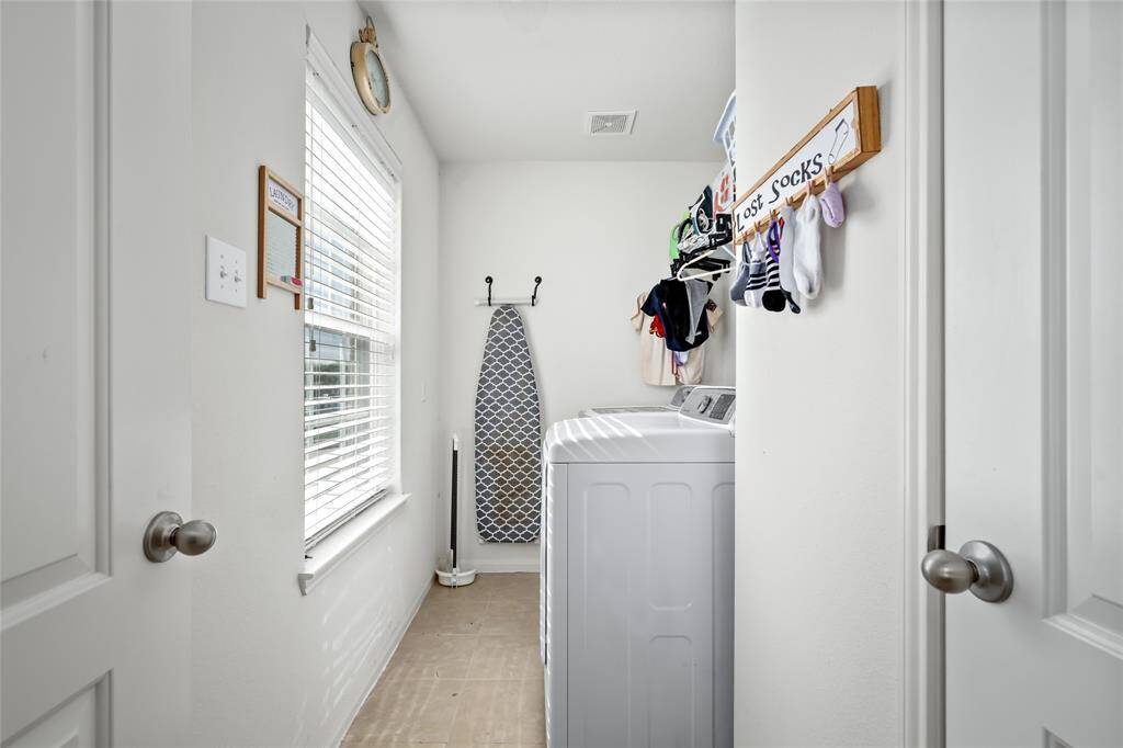 This compact utility room is efficiently designed, offering just the right amount of space for laundry essentials and quick storage. It’s a practical area that keeps chores organized without taking up too much room.