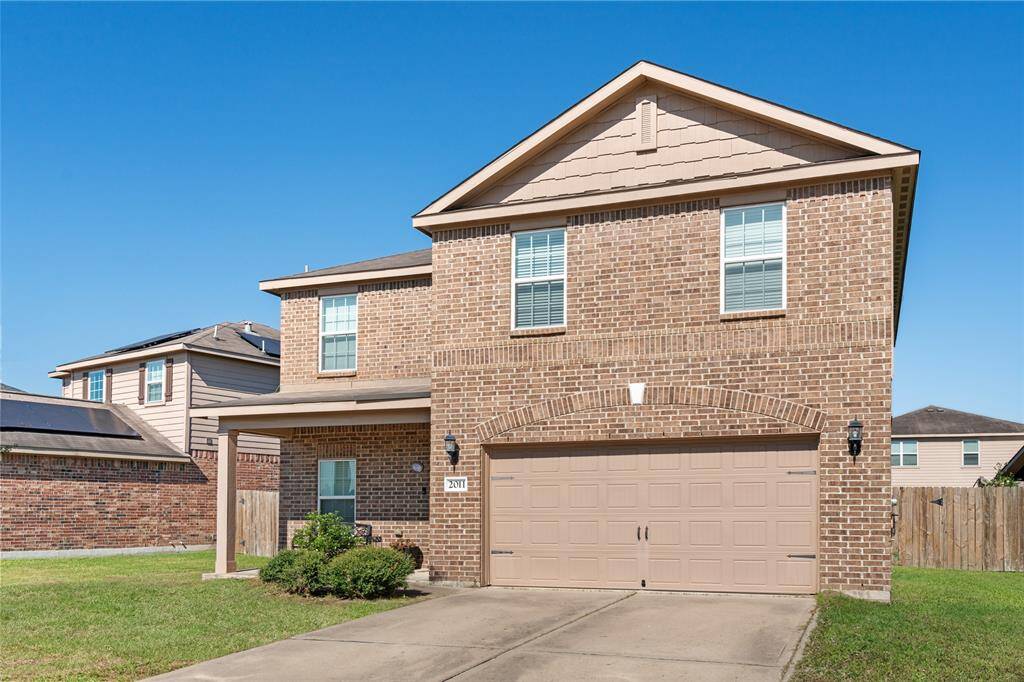 A beautifully maintained front lawn complements a cozy covered front porch, featuring lush green grass, well-kept flower beds, and inviting seating—a perfect spot to relax and enjoy the view.